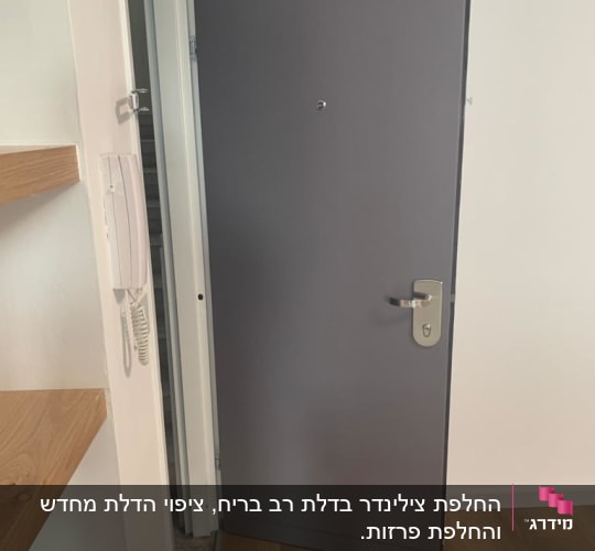 דלת מתכת אפורה עם ידית כסופה פתוחה חלקית
